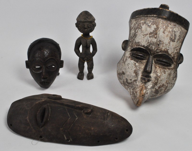 Een lot Afrikaans houtsnijwerk, bestaande uit een vruchtbaarheidsbeeldje en drie verschillende maskers, waarvan één van de Tikar, Kameroen.