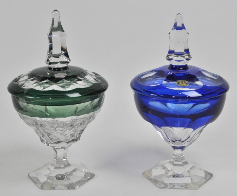 Twee drageoirs van geslepen kristal, resp. groen en blauw gekleurd in de massa. Gemerkt.