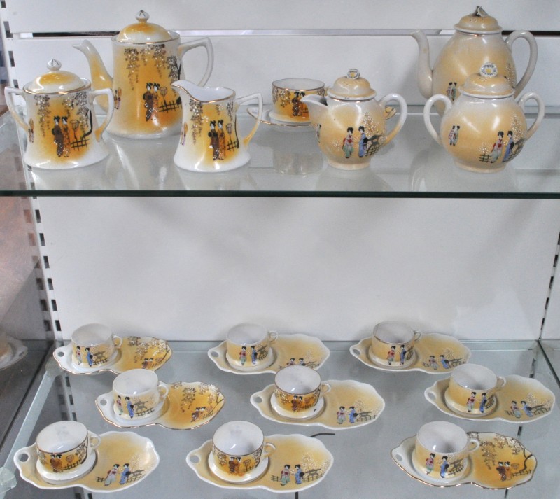 Een zes- en een vierdelig Chinees theeservies van meerkleurig porselein bestaande uit twee theepotten, twee melkkannetjes, twee suikerpotten, tien kopjes, waarvan één hersteld en tien gecompartimenteerde schoteltjes.