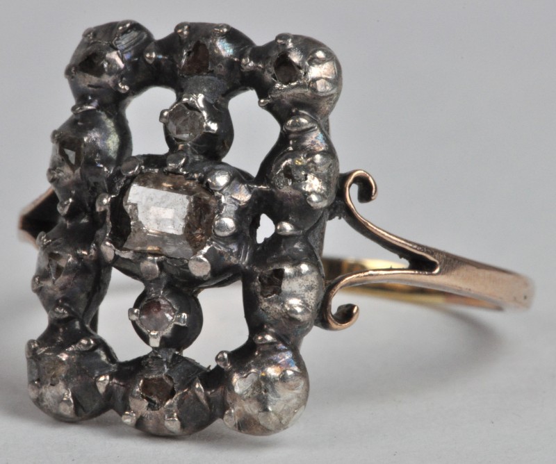 Een 18 karaats geel gouden ring met in zilver gezette diamanten oude slijp met een gezamenlijk gewicht van ± 0,40 ct.