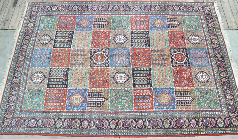 Een handgeknoopt Perzisch tapijt van wol op katoen met een dambordmotief.