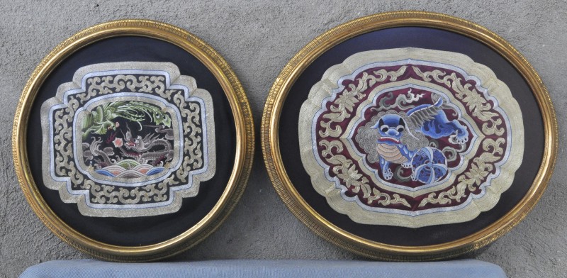 Twee ingelijste Chinese borduursels met drakenmotieven.