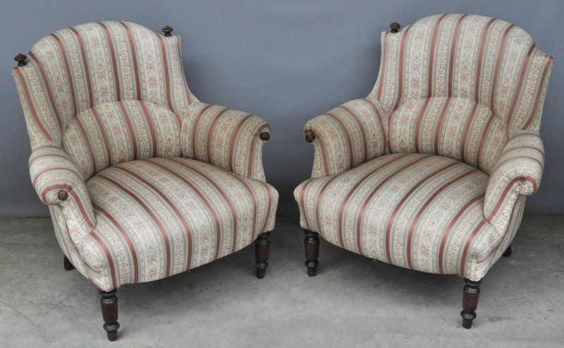 Twee fauteuils met poten van gesculpteerd notenhout met gecapitonneerde stoffen bekleding. Kleine beschadiging. XIXe eeuw.