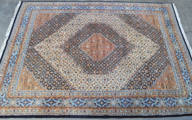 Een handgeknoopt wollen Perzisch tapijt.