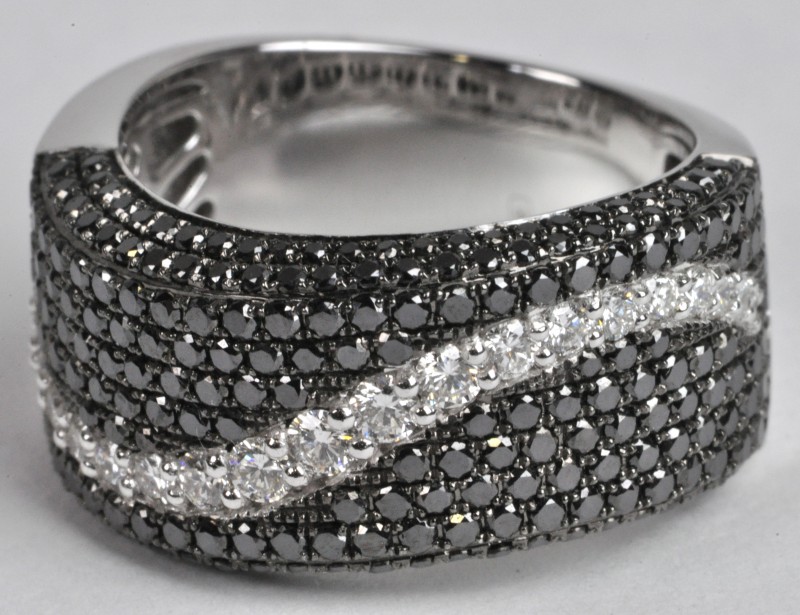 Een 18 karaats witgouden ring bezet met witte en zwarte diamanten met een gezamenlijk gewicht van ± 2 ct.
