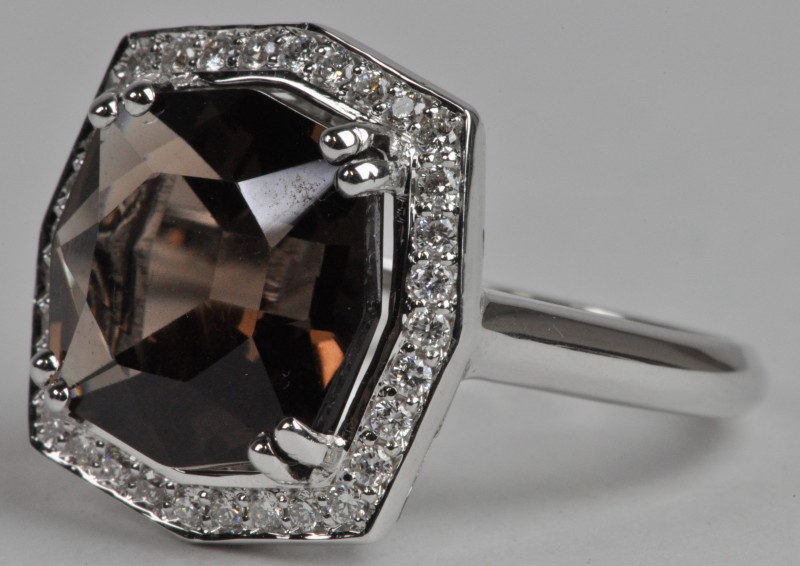 Een 18 karaats wit gouden ring bezet met diamanten met een gezamenlijk gewicht van ± 0,32 ct. en een centrale bruine kwarts van ± 5,92 ct.