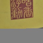 Een grote cilindervormige vaas van Chinees porselein, versierd met een kippendecor en Chinese tekens op gele fond.