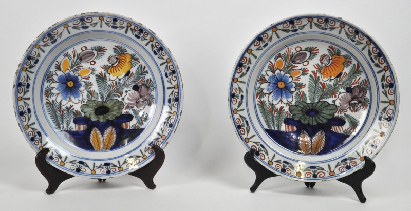 Een paar Delftse schotels van meerkleurig aardewerk met een tuindecor. XVIIIde eeuw.