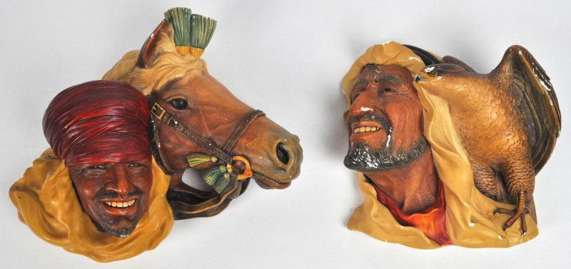 Een paar polychrome gipsen wandversieringen in de vorm van Arabische hoofden, den ene met een paard, de andere met een valk. Achteraan gemerkt Bossons England d.d. 1959. Schilfers aan de tweede.