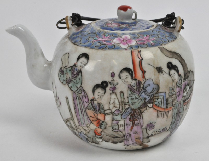 Een theepot van Chinees porselein, versierd met een decor van Geisha’s en Chinese tekens achteraan.