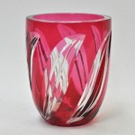 Een vaas van geslepen kristal, rood gekleurd in de massa. Onderaan gemerkt met gravure en label.