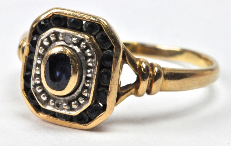 Een 18 karaats geel gouden ring bezet met twee briljantjes en saffieren met een gezamenlijk gewicht van ± 0,40 ct.
