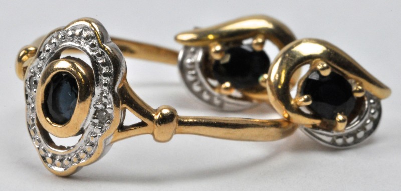 Een 18 karaats geel gouden ring met bijpassende oorbellen bezet met saffier gezamenlijk gewicht van ± 0,40 ct. en twee briljantjes.