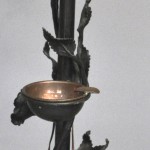 Een staande lamp van smeedijzer, versierd met rozenranken.