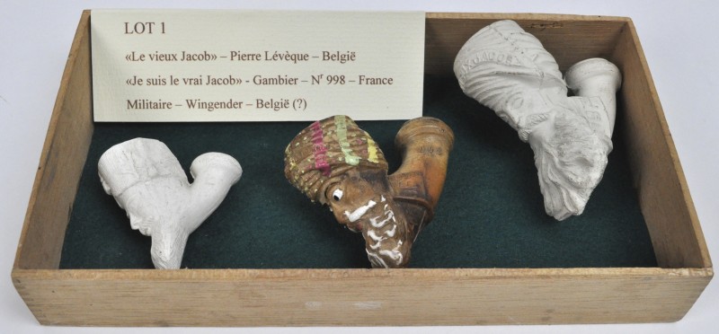 Een lot van drie oude aardewerken pijpen:- “Le vieux Jacob”. Pierre Lévèque, België.- “Je suis le vrai Jacob”. Gambier no. 998, Frankrijk.- “Militair”. Wingender, België.