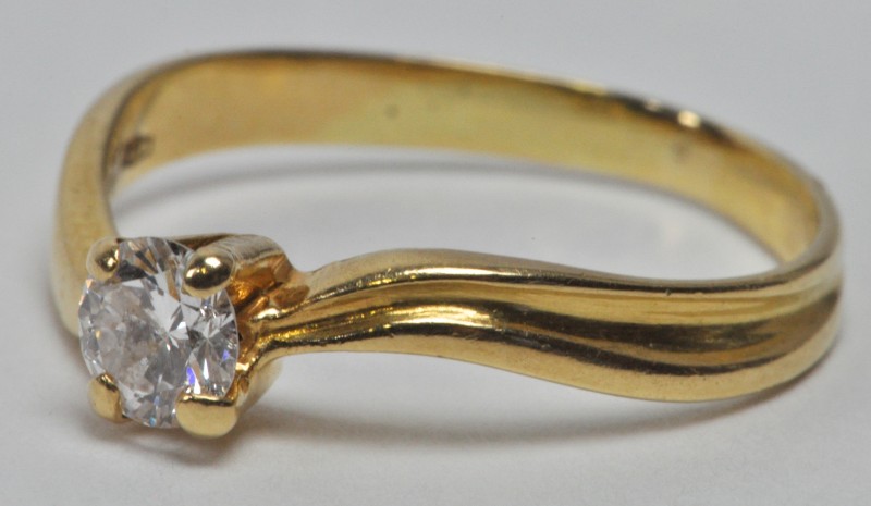 Een 18 karaats geel gouden ring bezet met één briljant van ± 0,20 ct.