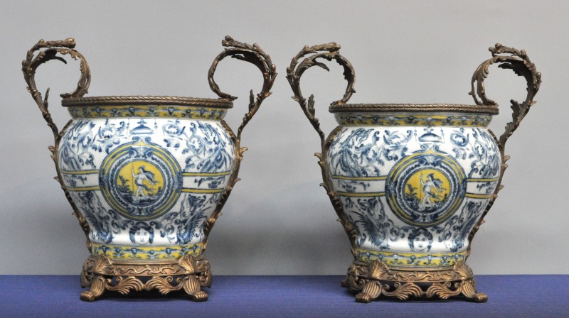 Twee cachepots van meerkleurig aardewerk met een decor van mythologische figuren en versierd met bronzen monturen. Onderaan gemerkt.