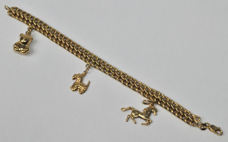 Een 18 karaats geel gouden schakelarmband met drie hangertjes