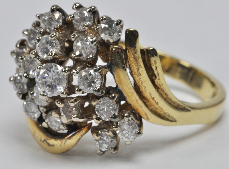 Een 18 karaats wit en geel gouden ring bezet met 18 briljanten met een gezamelijk gewicht van ± 1,50 ct.