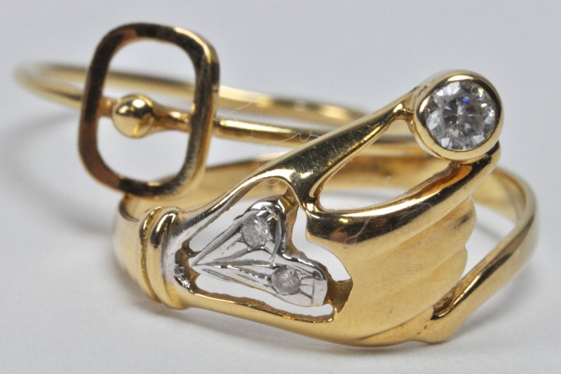 Twee ringen van 18 karaats geel goud, waarvan één in de vorm van een hand.