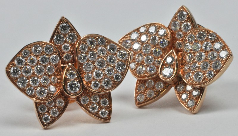 Een paar 18 karaats rooskleurige gouden oorbellen bezet met diamanten met een gezamenlijk gewicht van ± 1,40 ct.