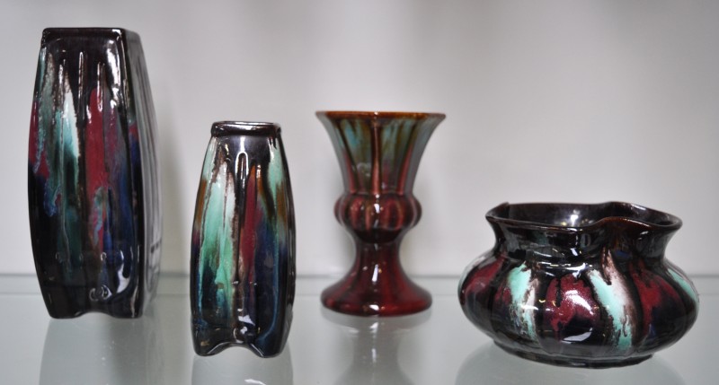 Een lot Belgisch Thulin aardewerk met meerkleurig glazuur, bestaande uit drie verschillende vazen en een schaal.