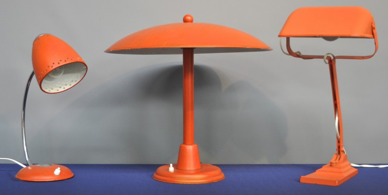 Drie vintage lampen van oranje gelakt metaal.