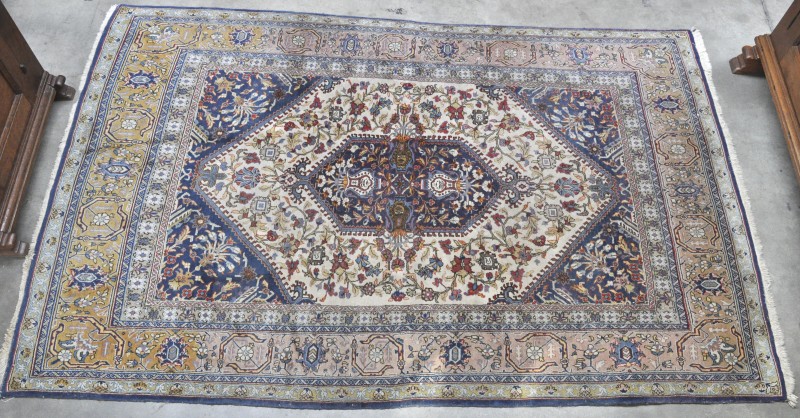 Een handgeknoopt Perzisch tapijt van zijde en wol.