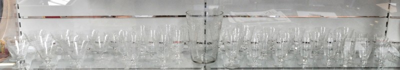 Een glazenservies van kleurloos kristal met een geslepen decor, bestaande uit elf champagnecoupes, twaalf rode wijnglazen, twaalf witte wijnglazen, twaalf likeurglaasjes en een koelemmer. XIXe eeuw.