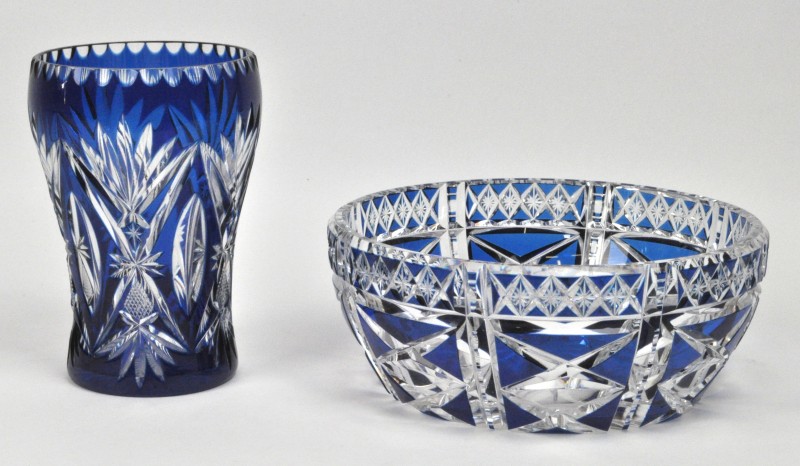 Twee stuks blauwkleurig geslepen kristal, bestaande uit een coupe en een vaas.