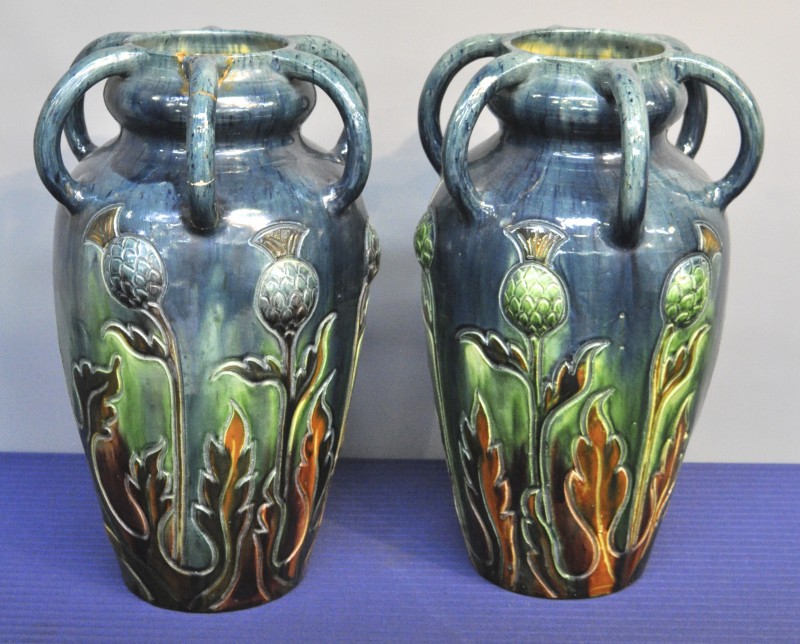 Twee grote vazen van Vlaams aardewerk met zes oren en een vegetaal decor in reliëf.