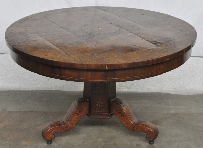Een lage ronde tafel op centrale driepoot. Volledig versierd met intarsia van diverse houtsoorten. XIXde eeuw.