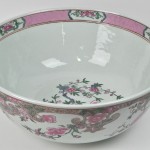 Grote kom van Chinees porselein met een famille rose versiering. Met apocrief keizerlijk merk op de basis.