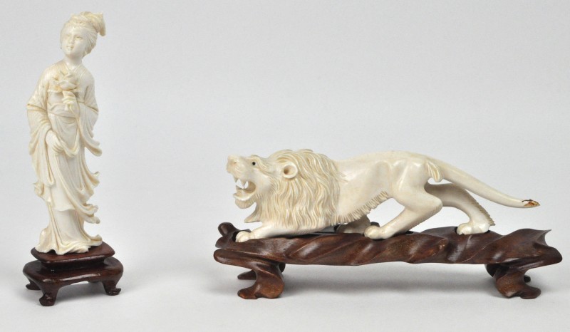 Een geisha en een leeuw van gesculpteerd Chinees ivoor op een houten sokkel.. Schade aan de staart van de leeuw.