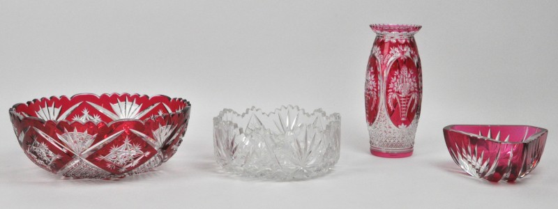 Een lot geslepen kristal bestaande uit een kleurloze coupe en een coupe, een vaas en een asbak rood gekleurd in de massa. De laatste gemerkt Val St. Lambert.
