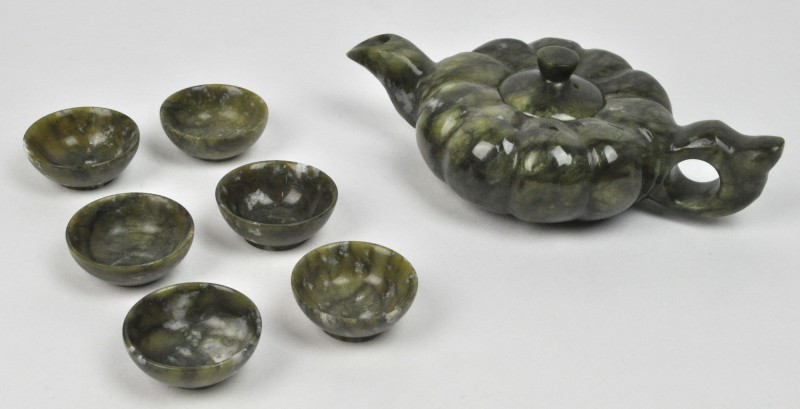 Een Chinees theepotje met zes bijhorende kopjes van gesculpteerd jade. In etui.