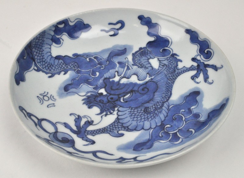 Een bord van blauw en wit Chinees porselein versierd met een drakendecor.