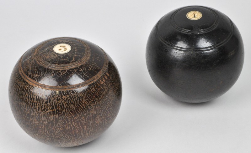 Twee Engelse bowls of koersballen van hout, afgewerkt met ivoor.