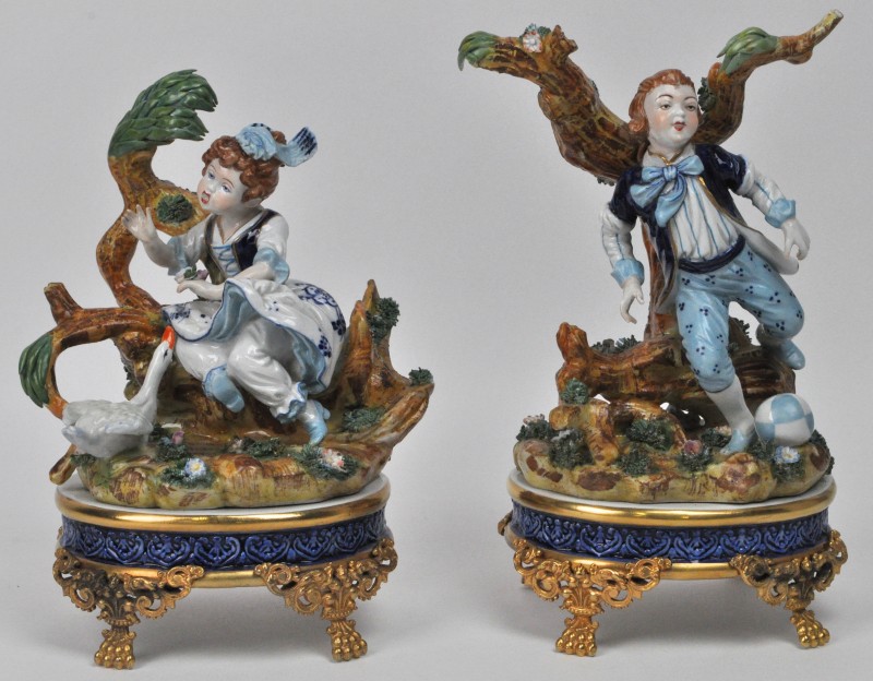 Twee groepjes van handgeschilderd meerkleurig porselein met voorstellingen van een jongen en een meisje. Naar het Sèvresporselein.