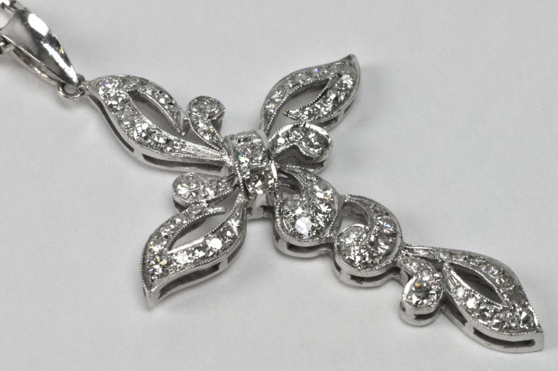 Een 18 karaats wit gouden ketting met hanger in de vorm van een kruis bezet met diamanten met een gezamenlijk gewicht van ± 1 ct.