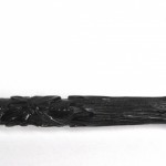 Een oud parasolletje van gesculpteerd en zwartgelakt hout.