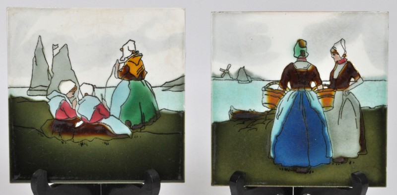 Een paar aardewerken tegels met meerkleurige decors van tradionele Hollandse dames onder glazuur.