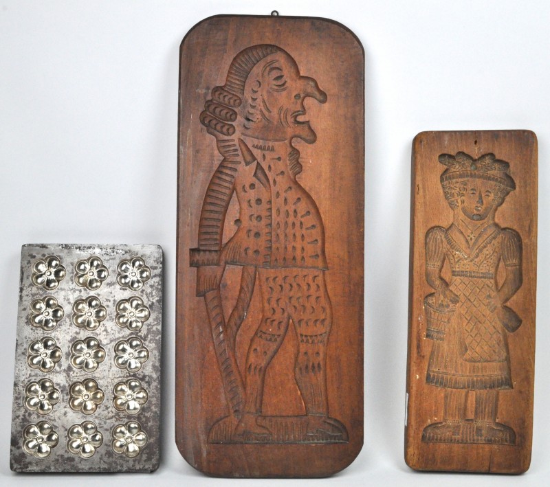 Twee houten speculaasplanken en een metalen chocoladevorm.
