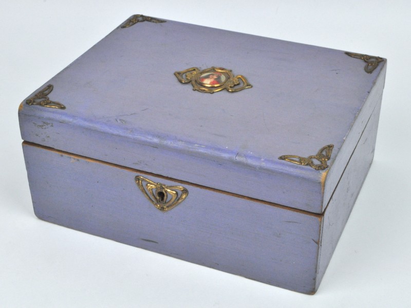 Een juwelenkoffertje van mauve gelakt hout met koperen beslag en een miniatuurportretje op het deksel.