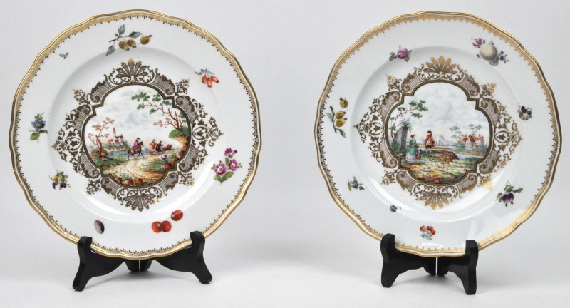Een paar porseleinen borden met een meerkleurig handgeschilderd decor en vergulde details. Achteraan gemerkt. XIXde eeuw.