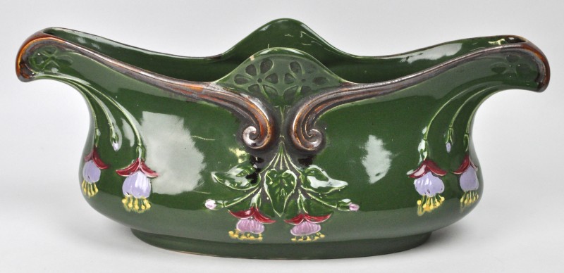 Een sierstuk van meerkleurig aardewerk in art nouveaustijl, versierd met een bloemendecor in reliëf.