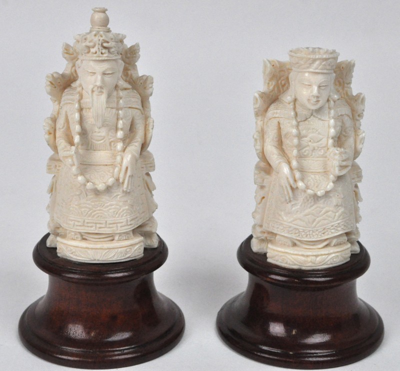 Twee voorstellingen van de Keizer en de Keizerin van gesculpteerd ivoor op houten sokkeltjes.