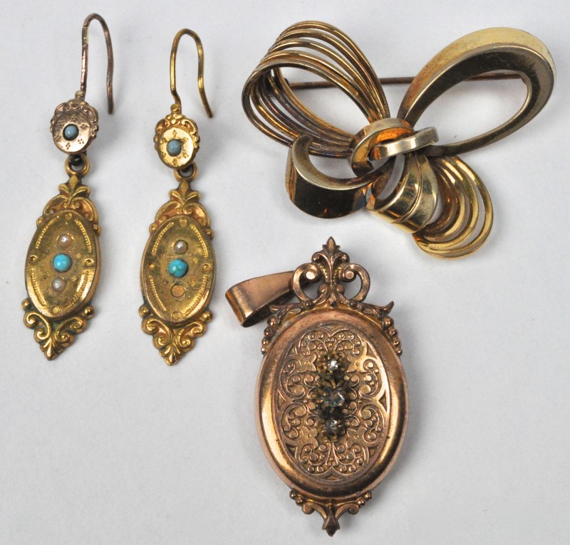 Een lot oude juwelen waaronder een hanger als fotohouder, een broche en een paar oorbellen.
