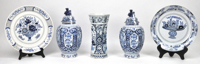 Een lot Delfts aardewerk, bestaande uit twee dekselvaasjes, een hoog vaasje en twee borden. De eerste twee XIXe eeuws.