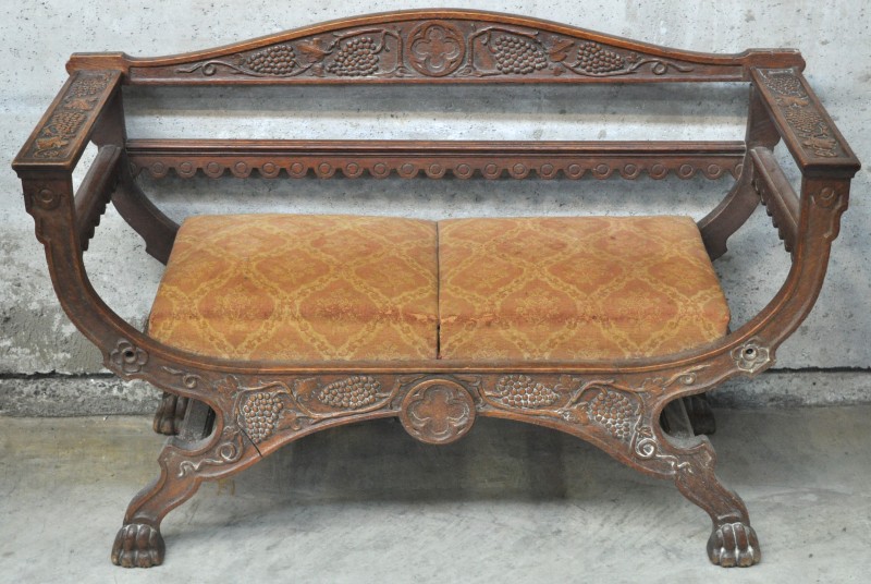 Een neogothische zitbank van gesculpteerd hout, versierd met druivenranken. XIXde eeuw.